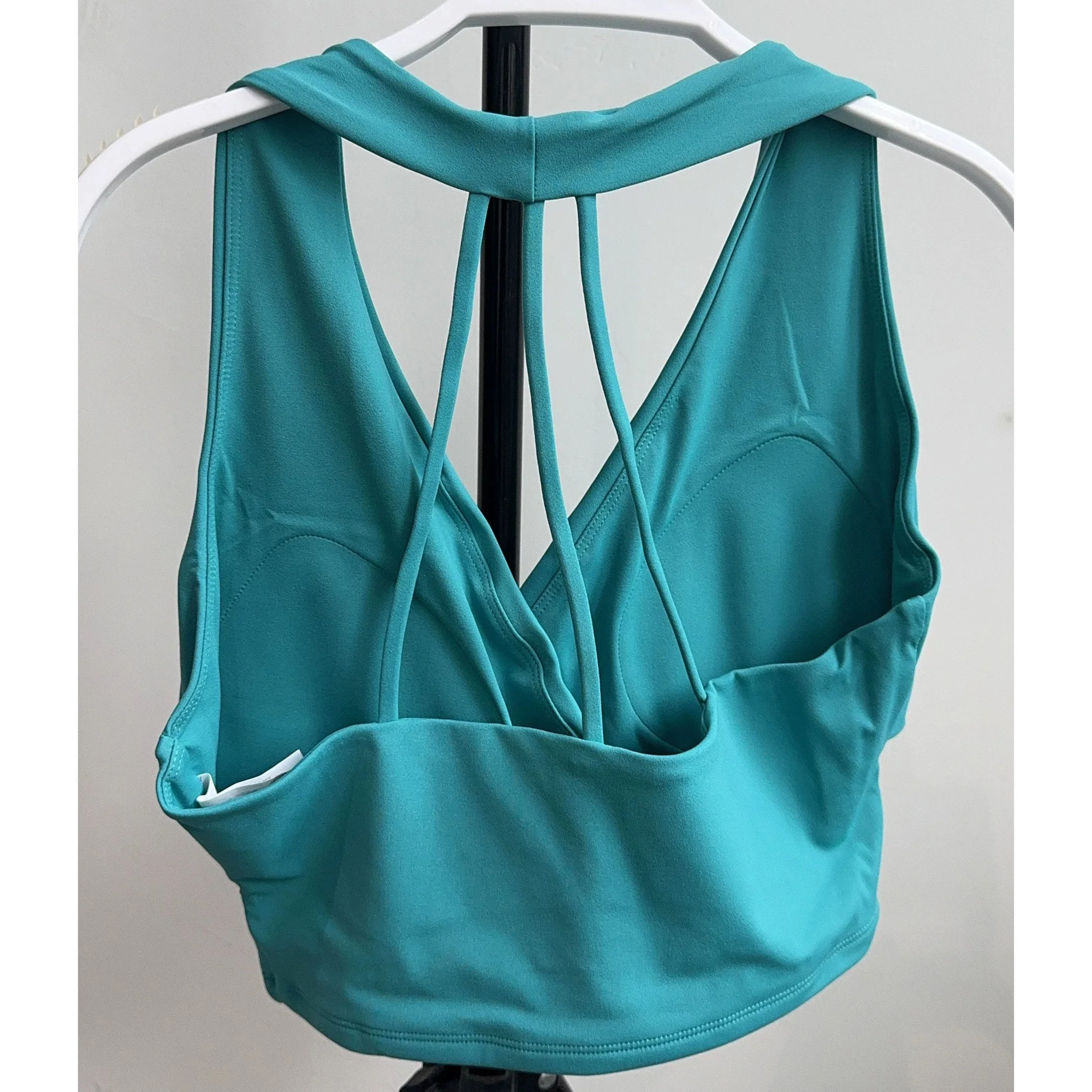 Back view of turquoise sports bra with slim straps and padded cups