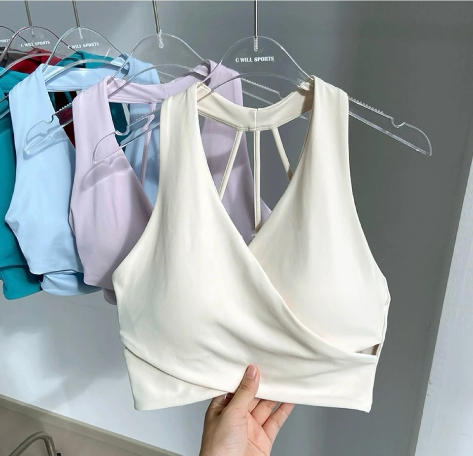 White wrap-front sports bra displayed with multiple color options